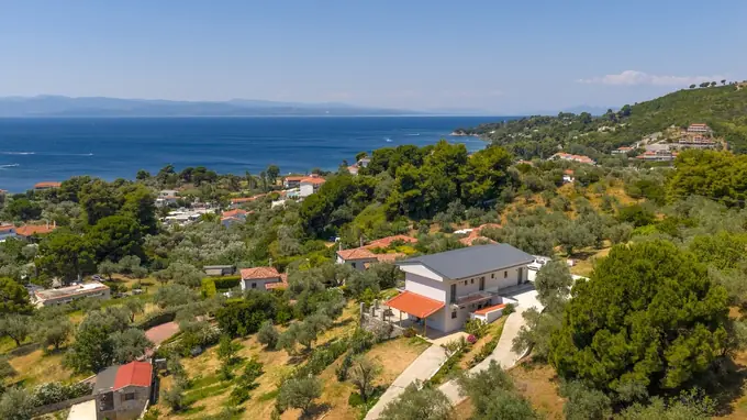 The Melina building on the hillside above the bay, seen from the air