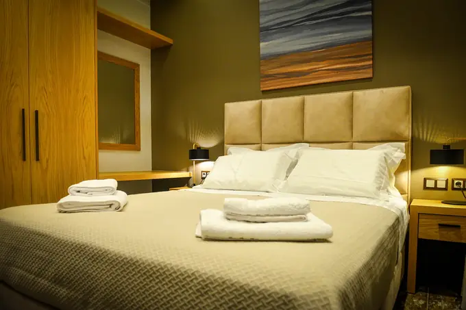Double bedroom with an upholstered headboard and a seascape painting