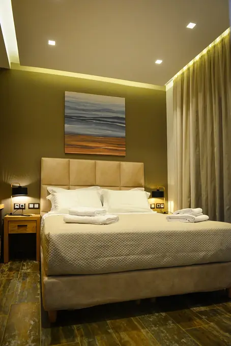 The double bedroom with cove lighting and a seascape painting