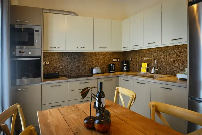 Kitchen with oven, microwave and a wooden dining table
