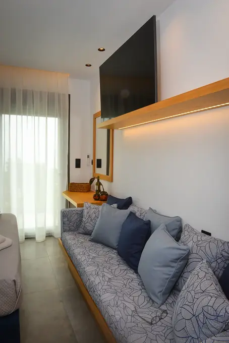 Window seat with blue cushions beneath the wall TV