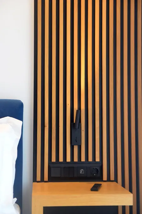 Slatted oak panel and bedside shelf by the blue headboard