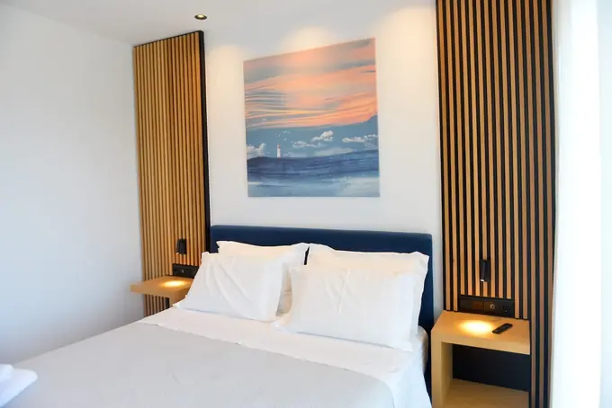 Bedroom with a blue headboard beneath a sunset seascape painting