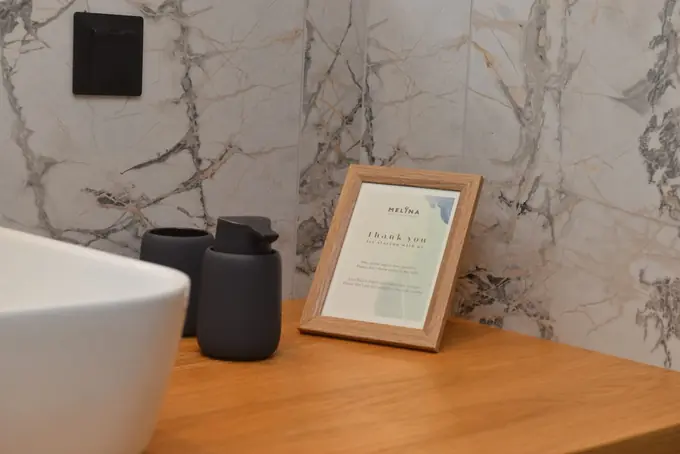 Marble bathroom with a welcome card