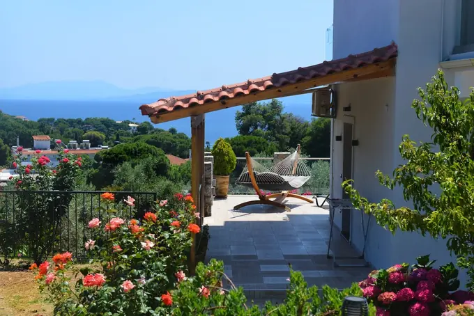 The pergola terrace with its hammock, roses in the garden