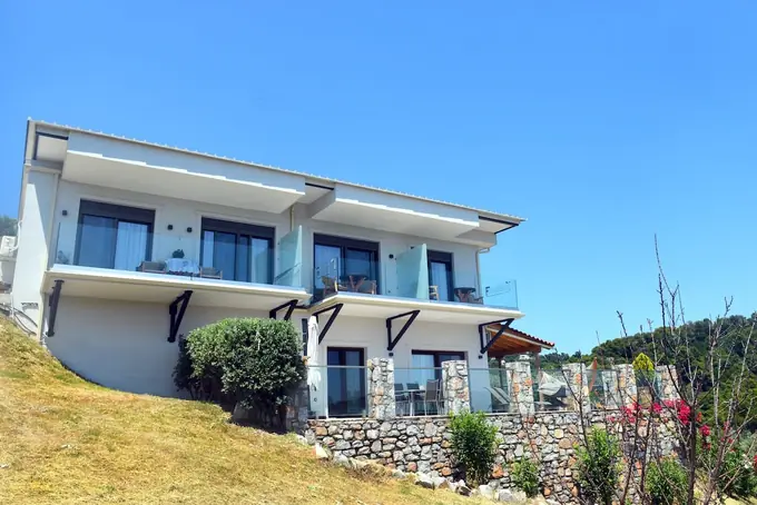 The white building above its stone retaining wall
