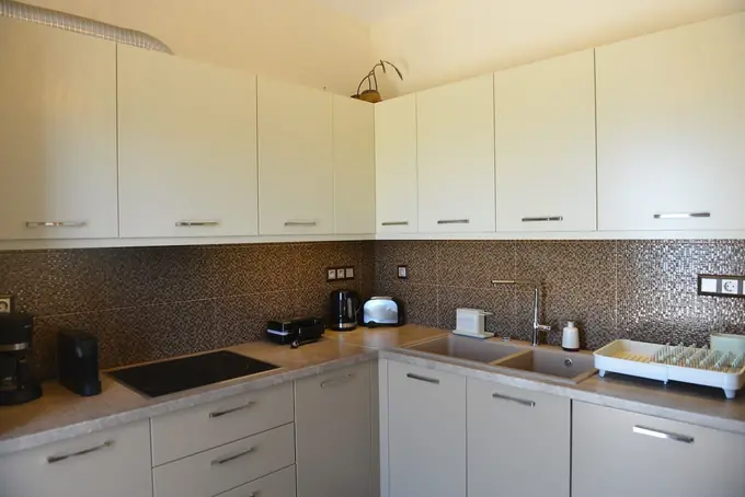 Kitchen with white cabinets and a mosaic splashback