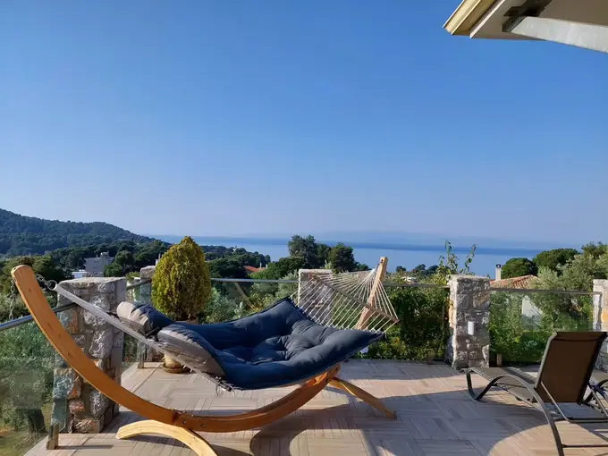 The hammock on the terrace with the sea and hills beyond