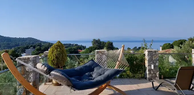 Terrace with a hammock and sun loungers facing the sea